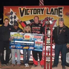 Crew Members Holding a Large Check & Flag